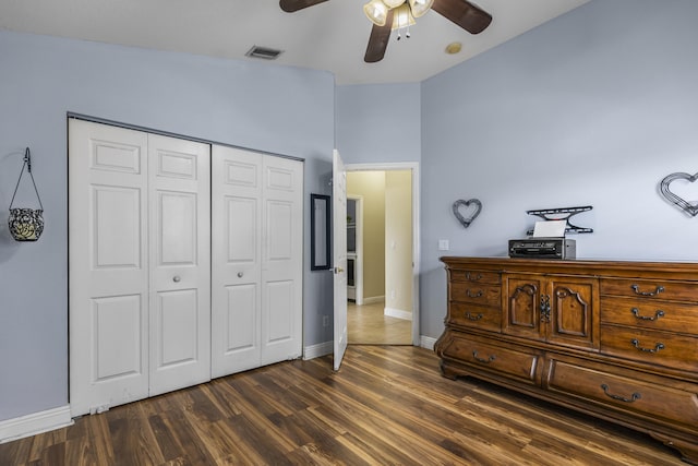 bedroom with ceiling fan, lofted ceiling, a closet, and dark hardwood / wood-style flooring