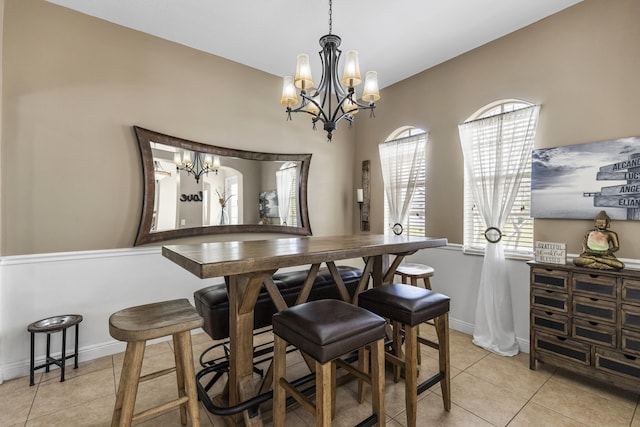 tiled dining area featuring a chandelier