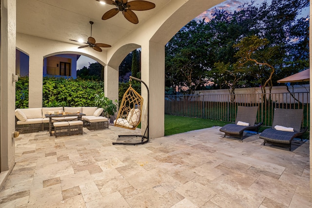 patio terrace at dusk with ceiling fan and an outdoor hangout area