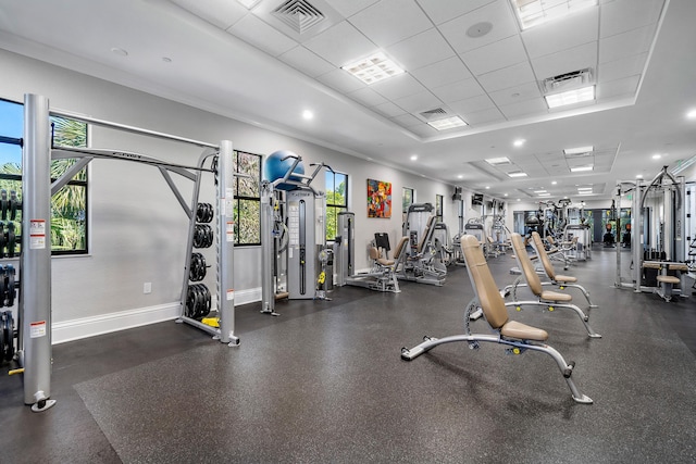 gym with a paneled ceiling and ornamental molding