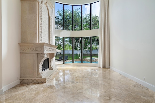 unfurnished living room with a fireplace and a high ceiling