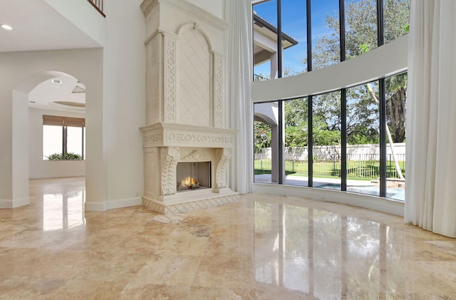 unfurnished living room with a premium fireplace and a high ceiling