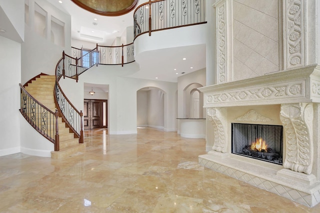 entrance foyer featuring a high ceiling and a high end fireplace