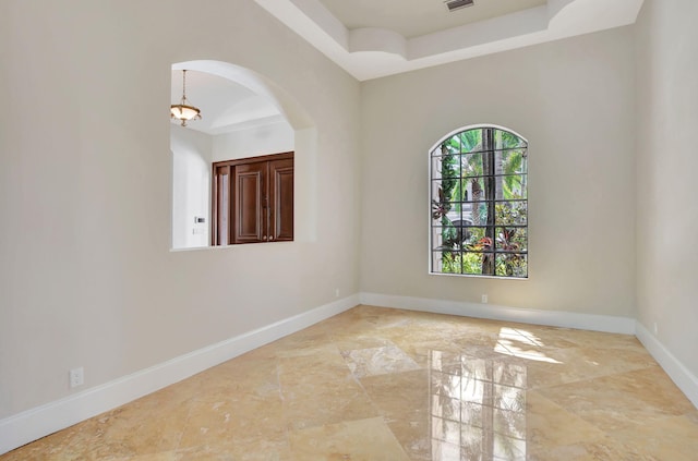 unfurnished room featuring a tray ceiling