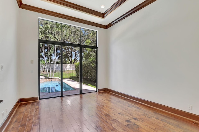 unfurnished room featuring ornamental molding and hardwood / wood-style flooring