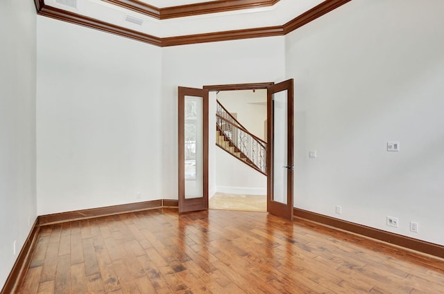 unfurnished room with french doors, crown molding, and light hardwood / wood-style flooring