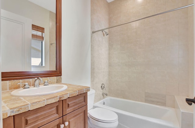 full bathroom featuring toilet, vanity, and tiled shower / bath