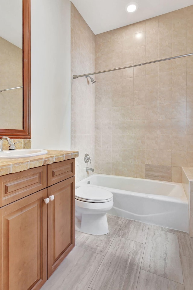 full bathroom with toilet, tiled shower / bath combo, and vanity