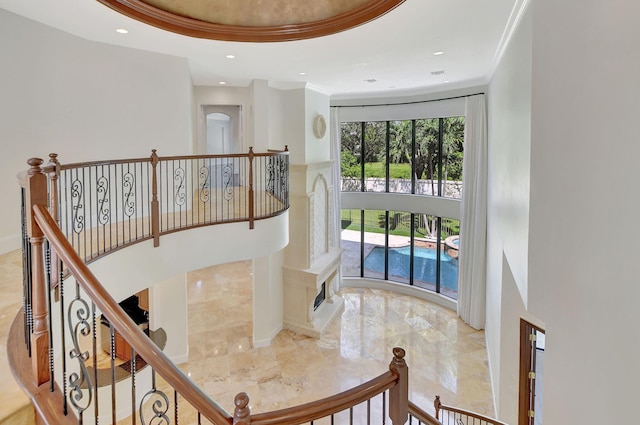 stairs with a tray ceiling and crown molding