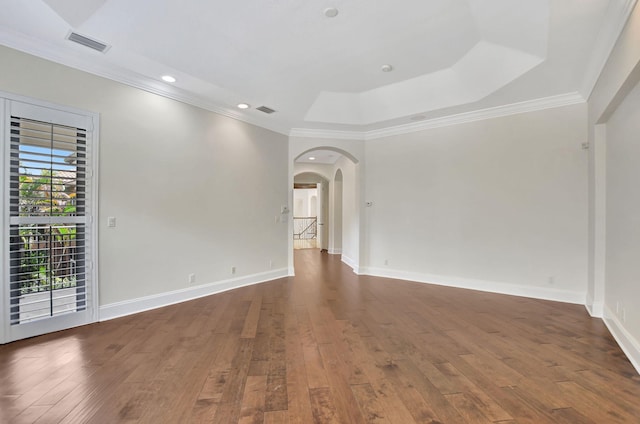 unfurnished room featuring a tray ceiling, dark hardwood / wood-style flooring, and crown molding