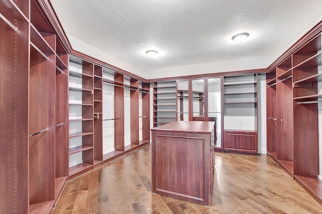 walk in closet with light wood-type flooring