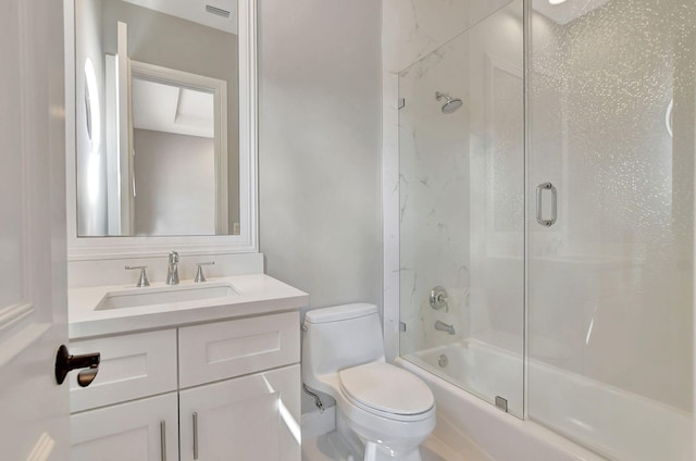 full bathroom featuring bath / shower combo with glass door, toilet, and vanity