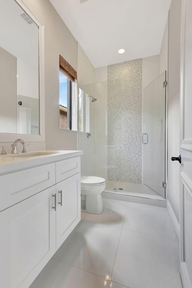 bathroom with toilet, vanity, tile patterned flooring, and a shower with door