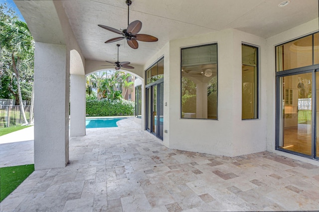 view of patio / terrace with ceiling fan and a fenced in pool