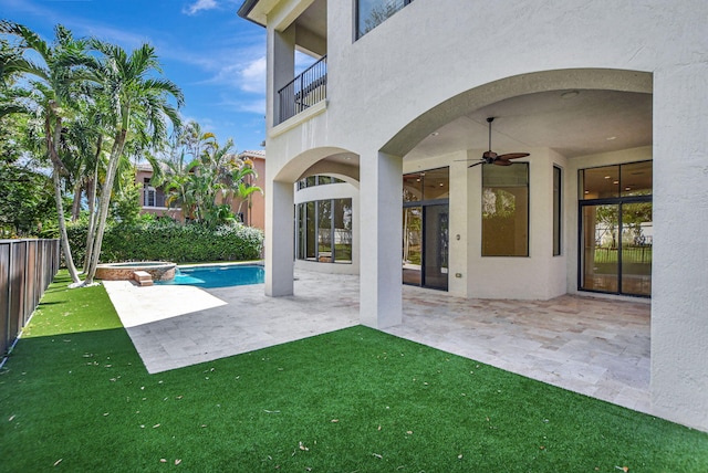 view of pool featuring ceiling fan, a patio area, a yard, and an in ground hot tub