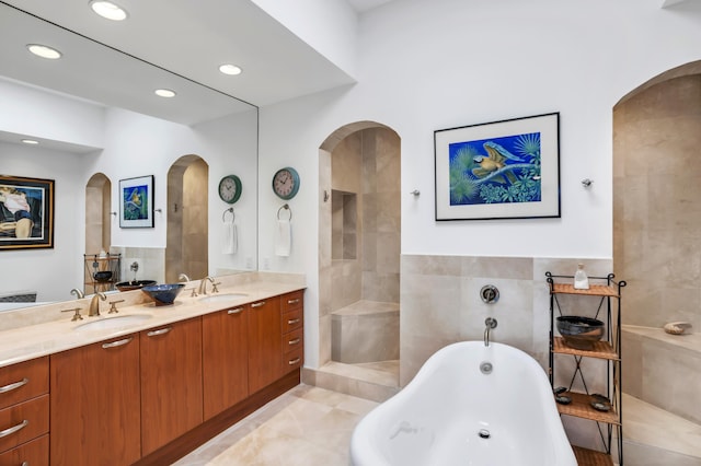 bathroom featuring vanity, tile walls, and a bathtub