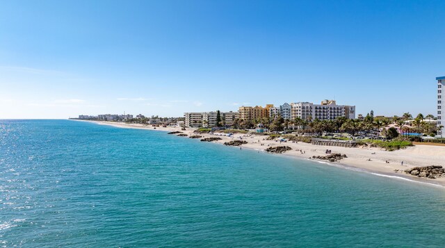 drone / aerial view with a water view and a view of the beach