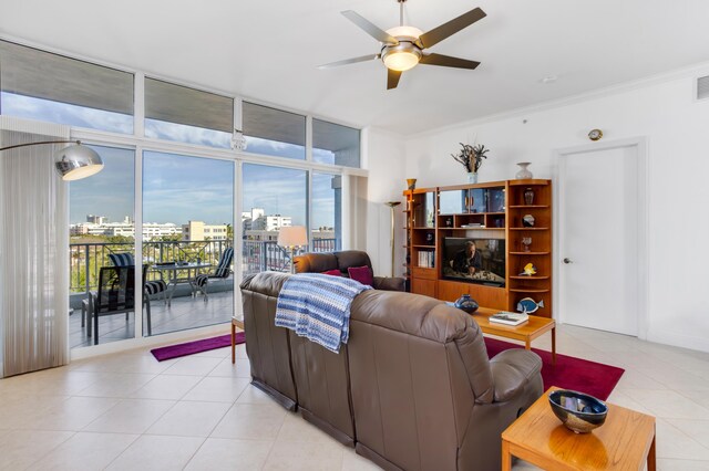 tiled living room featuring expansive windows, crown molding, and ceiling fan