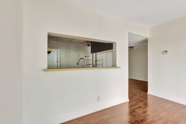 interior space with sink, wood-type flooring, and a textured ceiling