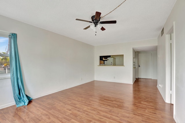 unfurnished living room featuring ceiling fan, a textured ceiling, and light wood-type flooring