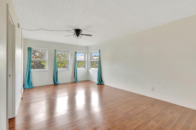 empty room featuring ceiling fan, wood-type flooring, and a textured ceiling