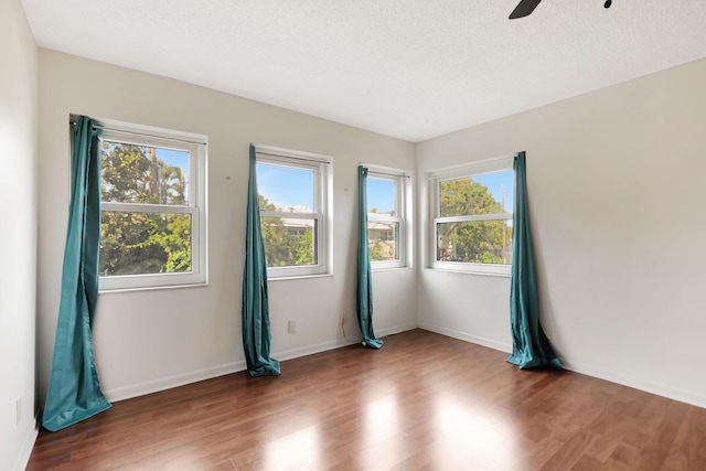 spare room with ceiling fan, dark hardwood / wood-style floors, and a textured ceiling