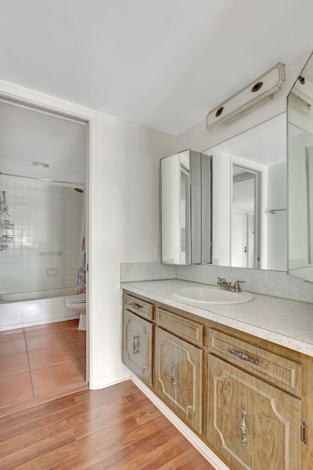 full bathroom with toilet, vanity, shower / bath combination with curtain, and hardwood / wood-style floors