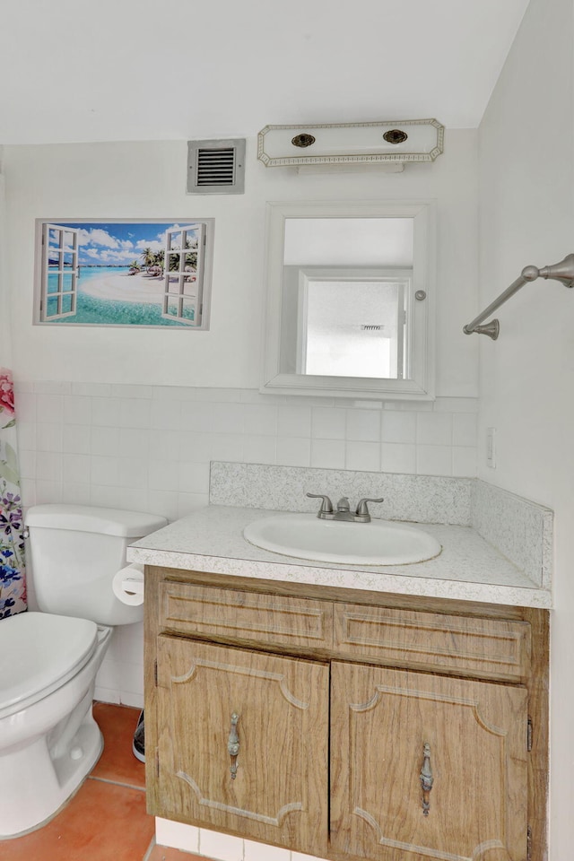 bathroom with toilet, decorative backsplash, tile patterned flooring, tile walls, and vanity