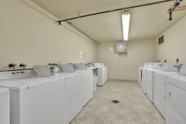 laundry area featuring separate washer and dryer and light tile patterned floors