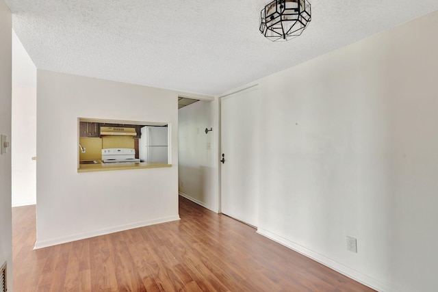 unfurnished room with sink, a textured ceiling, and hardwood / wood-style floors