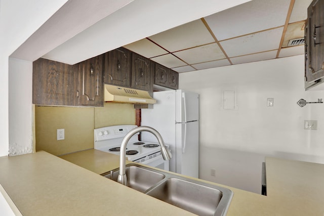 kitchen featuring a paneled ceiling, sink, white appliances, and dark brown cabinetry