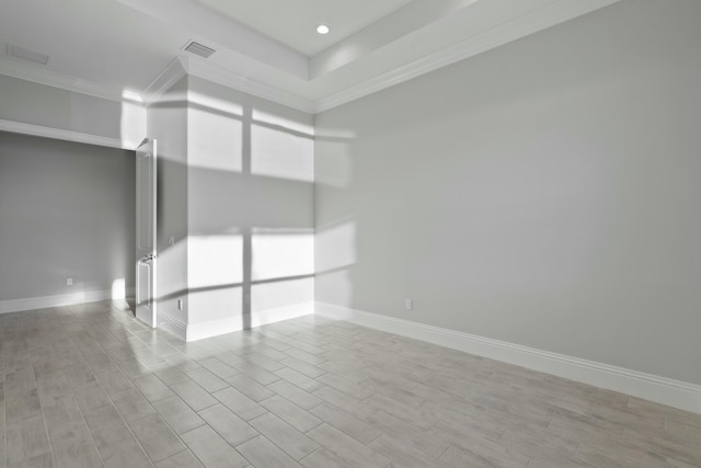 spare room featuring ornamental molding and light wood-type flooring