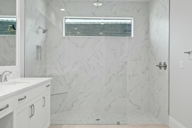 bathroom with vanity and tiled shower