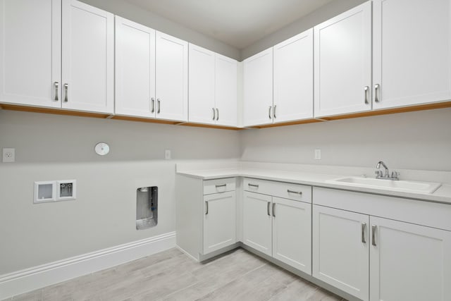 laundry room with cabinets, sink, washer hookup, and light hardwood / wood-style floors