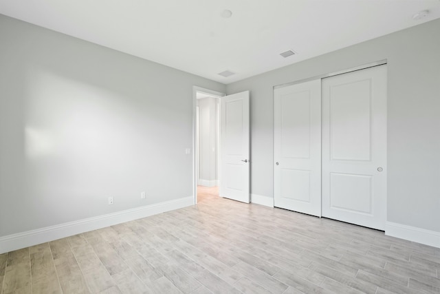 unfurnished bedroom featuring a closet and light hardwood / wood-style flooring