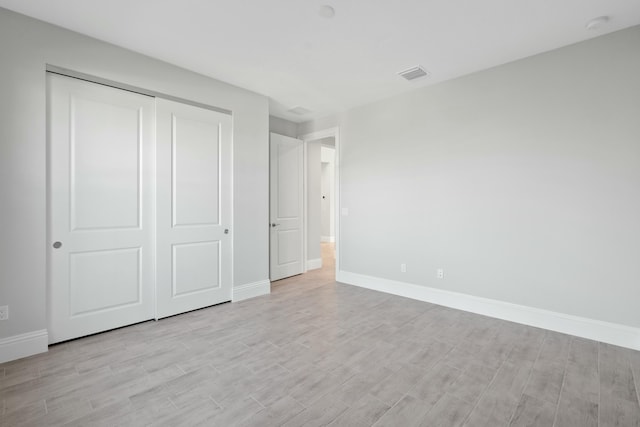 unfurnished bedroom featuring light hardwood / wood-style floors and a closet