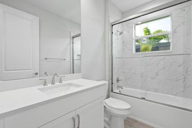 full bathroom featuring vanity, toilet, combined bath / shower with glass door, and wood-type flooring