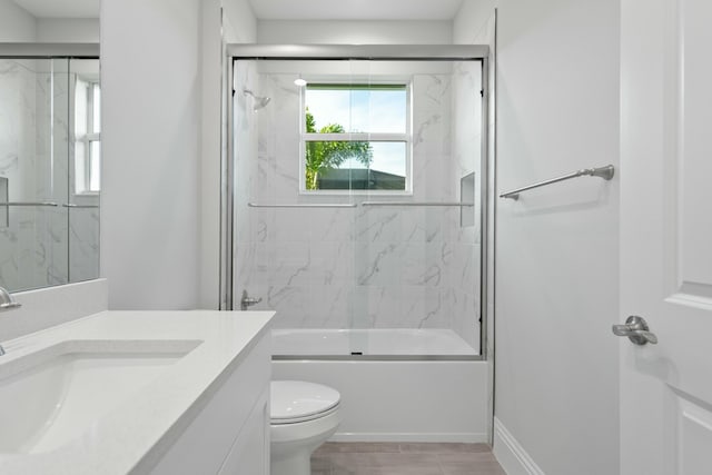 full bathroom featuring vanity, enclosed tub / shower combo, and toilet