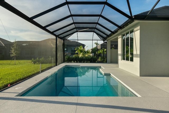 view of swimming pool featuring a yard, a patio area, and glass enclosure