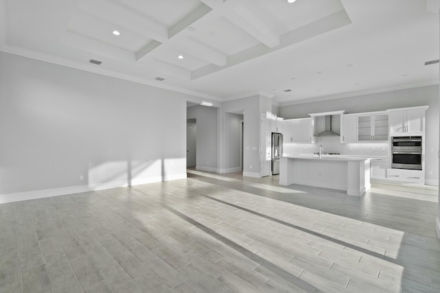 unfurnished living room with coffered ceiling, sink, ornamental molding, and beamed ceiling