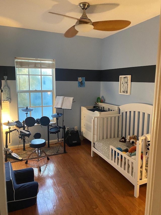 bedroom with dark hardwood / wood-style floors and ceiling fan