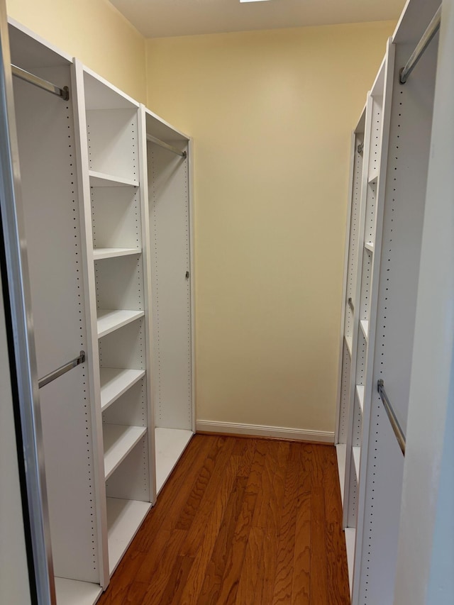 spacious closet with dark wood-type flooring