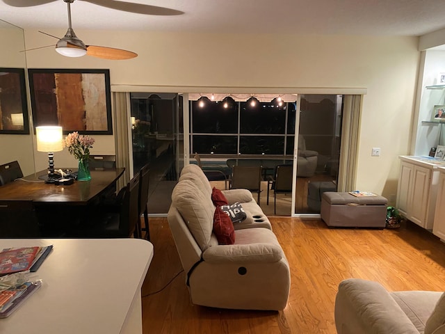 living room with ceiling fan and light wood-type flooring