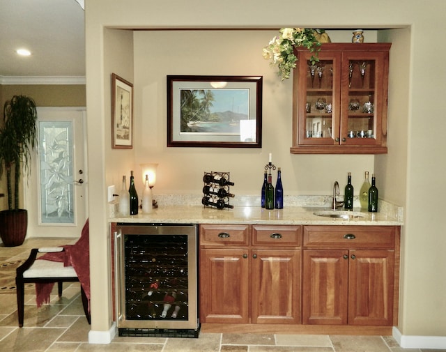 bar featuring wine cooler, sink, light stone counters, and ornamental molding