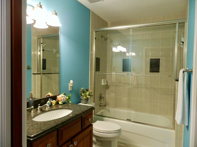 full bathroom featuring vanity, bath / shower combo with glass door, and toilet