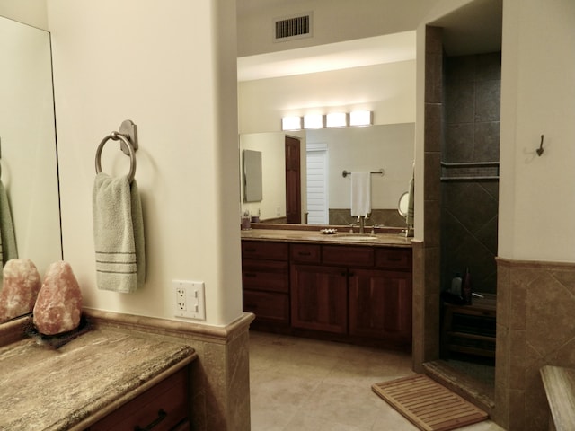 bathroom featuring tile patterned flooring, vanity, and tile walls