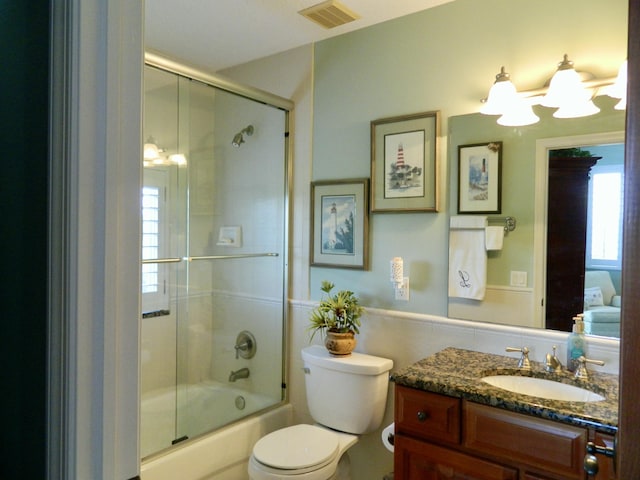 full bathroom featuring enclosed tub / shower combo, vanity, and toilet