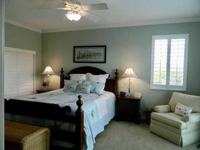 carpeted bedroom with ornamental molding and ceiling fan