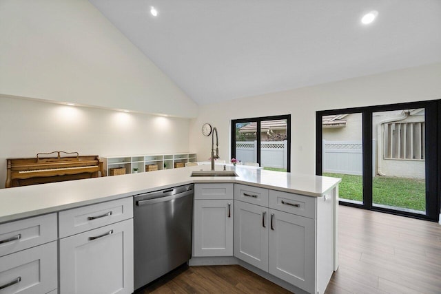 kitchen featuring white cabinetry, dishwasher, sink, dark hardwood / wood-style flooring, and kitchen peninsula