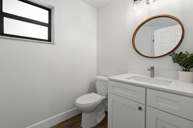 bathroom with toilet, hardwood / wood-style flooring, and vanity